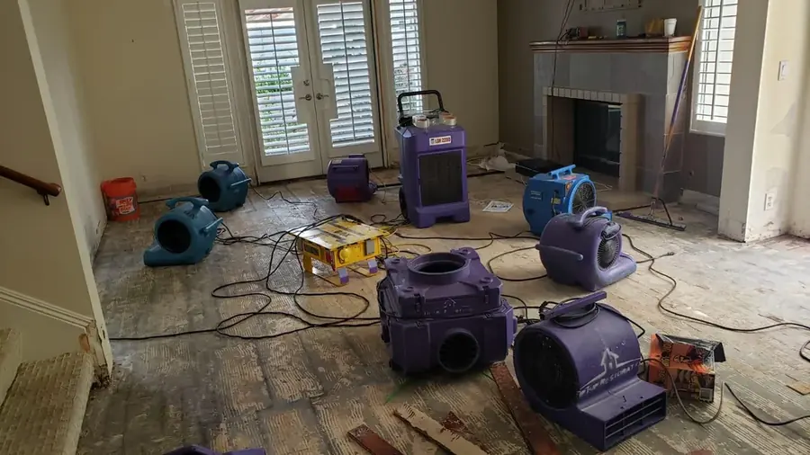 Drying equipment working on a wet carpeted room after water damage